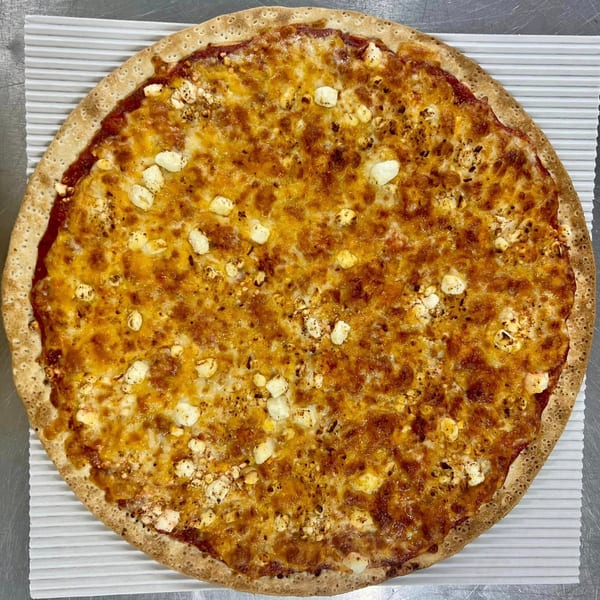 A whole Casa Di Pizza cheese pizza with a golden crust and melted cheese, topped with feta.