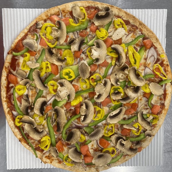 A Casa Di Pizza veggie pizza with mushrooms, green peppers, banana peppers, tomatoes, and onions.